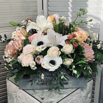 Mixed bouquet of pale pink and white flowers in a wooden box