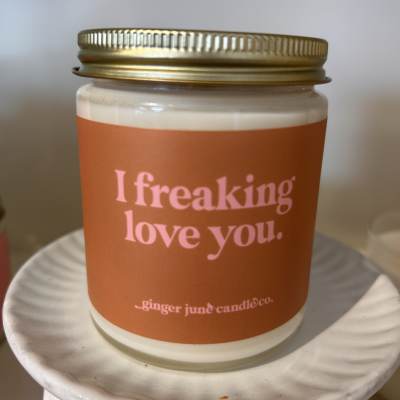 Orange-labeled candle in a glass jar with a gold lid