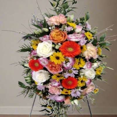 Large standing floral spray with mixed roses and daisies on an easel