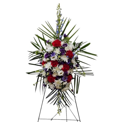 Standing floral spray with red, white, and purple flowers on an easel