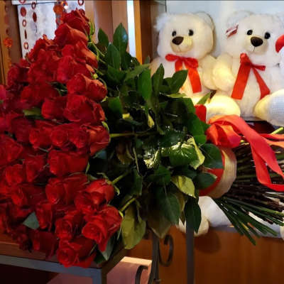 Large bouquet of red roses with teddy bears in the background