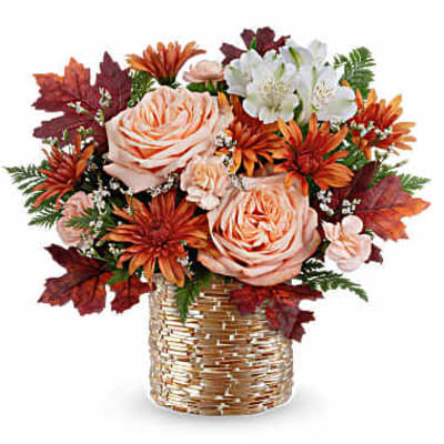 Bouquet of peach roses and orange flowers in a woven vase