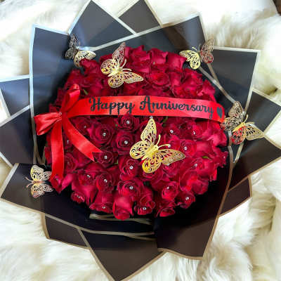 Red rose bouquet with a Happy Anniversary ribbon and butterfly decorations