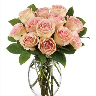 Pink and cream roses arranged in a clear glass vase