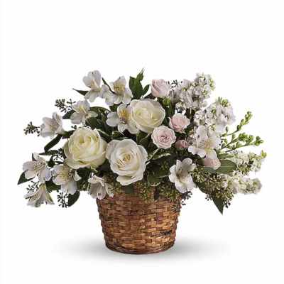 White and pale pink roses with white alstroemeria arranged in a woven basket.
