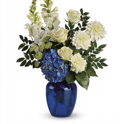 White and blue floral arrangement in a cobalt vase