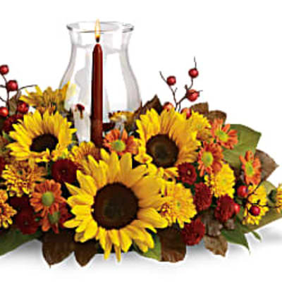 Sunflower and autumn flower centerpiece around a glass candle holder