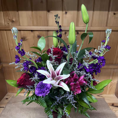 Mixed bouquet with lilies, roses, and purple flowers in a vase