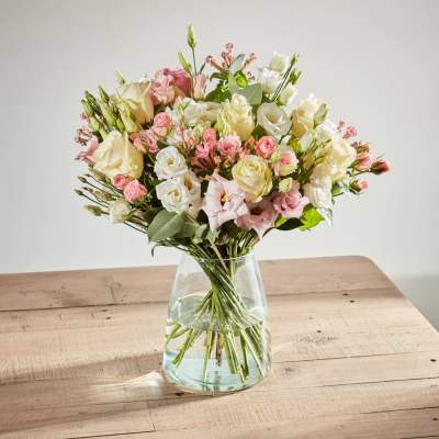 Bouquet of pink and white roses in a clear glass vase