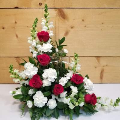 Red roses and white carnations arranged in a clear glass vase
