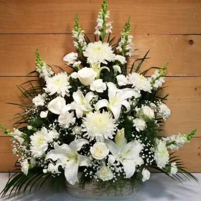 White lilies, roses, and chrysanthemums in a basket arrangement