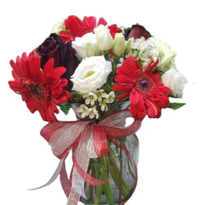 Bouquet of red gerbera daisies and white roses in a glass vase