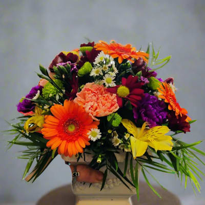 Bright mixed bouquet in a white pedestal vase