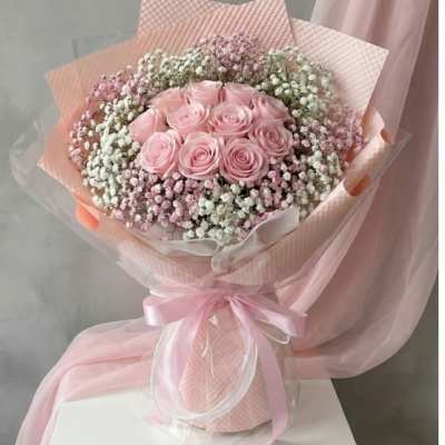 Pink rose bouquet wrapped in pastel paper with a ribbon