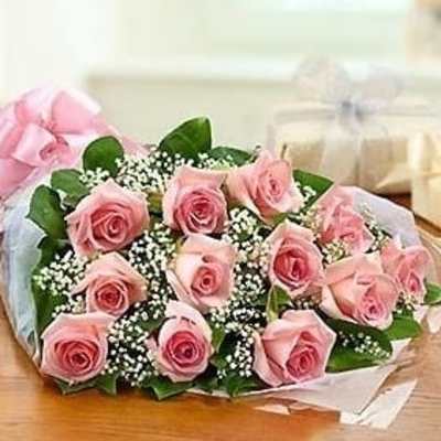 Bouquet of pink roses with baby's breath wrapped in pink and white paper