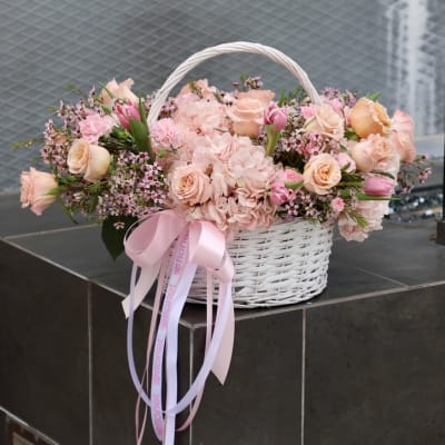 Pink and peach flower basket with a ribbon bow