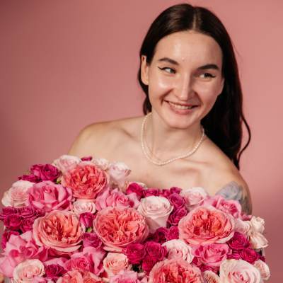 Woman holding a large pink rose bouquet in a box