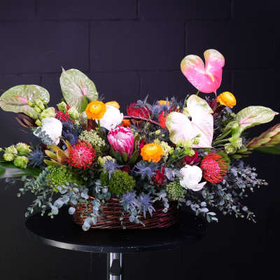 Colorful mixed flower arrangement in a wicker basket
