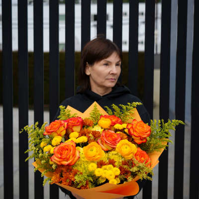 Large bouquet of orange and yellow roses with small yellow flowers