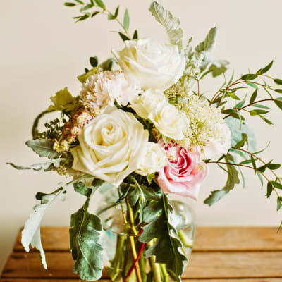 Bouquet of white and pink roses in a clear glass vase