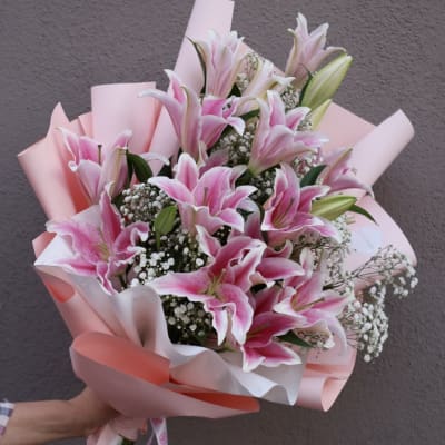 Pink lily bouquet wrapped in pastel paper