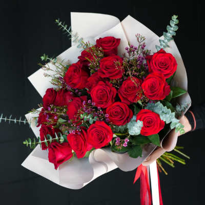 Bouquet of red roses wrapped in white paper