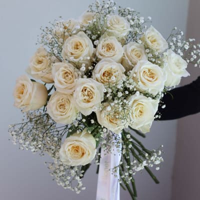 Bouquet of cream roses with baby's breath and a white ribbon