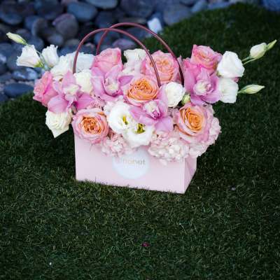 Pink and white floral arrangement in a pink gift box with handles