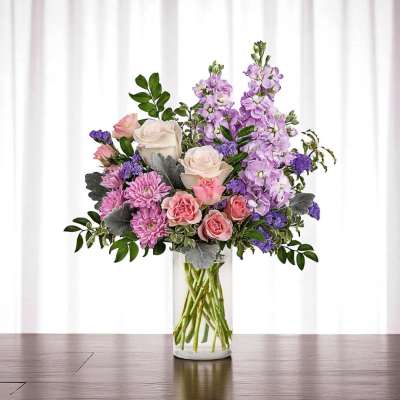 Pink and lavender flower arrangement in a clear glass vase