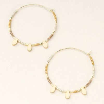 Pair of gold-tone hoop earrings with neutral seed beads and small teardrop charms.