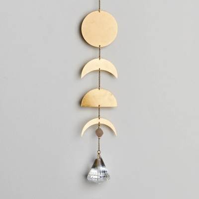 Hanging gold metal wall decor with moon phases and a faceted crystal prism