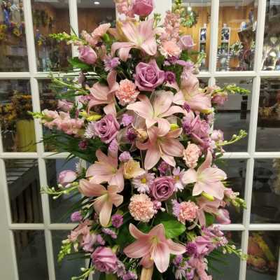 Tall pink floral standing spray with lilies, roses, and carnations