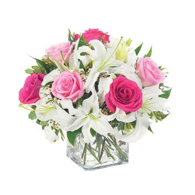 Pink and white roses with white lilies in a clear glass vase