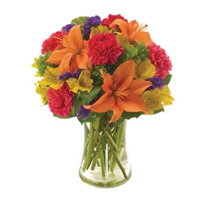 Bouquet of orange lilies, red carnations, and purple flowers in a clear glass vase