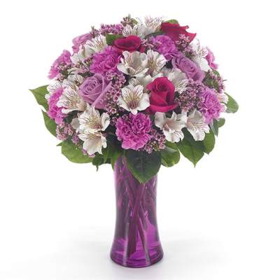 Pink and white mixed bouquet in a purple glass vase