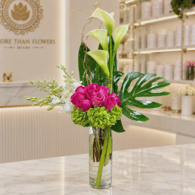 Pink roses and green calla lilies in a clear glass vase