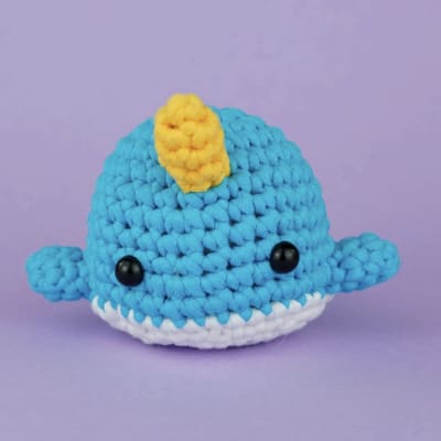 Crocheted blue whale plush with a yellow fin and white belly