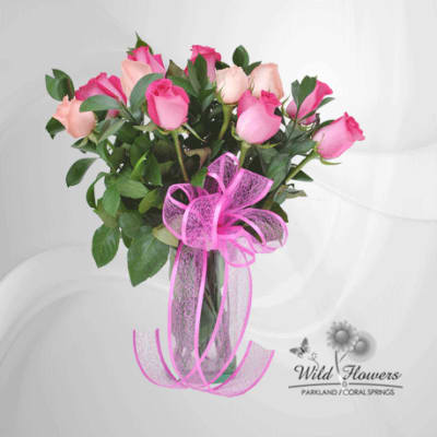Bouquet of pink and peach roses tied with a pink ribbon