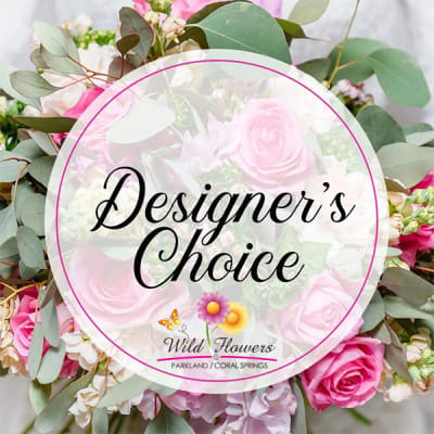 Pink roses and mixed flowers with eucalyptus around a Designer's Choice sign