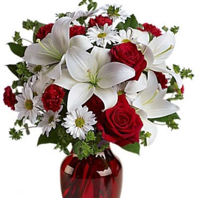 Red roses and white lilies in a red glass vase