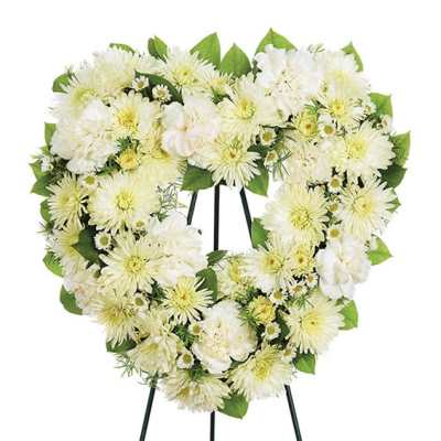 Heart-shaped white floral wreath on a stand