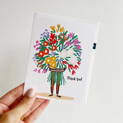 Handheld thank-you card with a colorful illustrated bouquet on the front