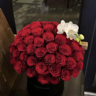 Large red rose arrangement with white orchids in a black hat box