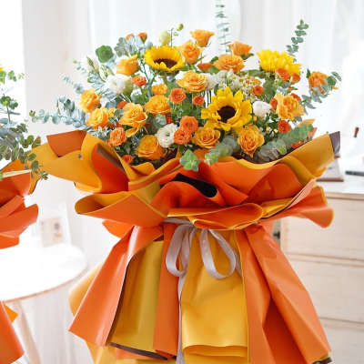 Bouquet of yellow and orange flowers wrapped in bright orange paper