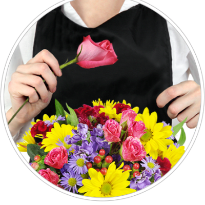 Person holding a pink rose above a colorful mixed bouquet