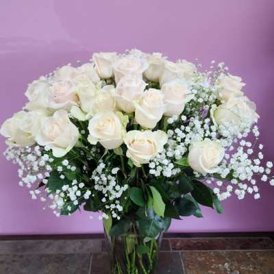 Bouquet of white roses and baby's breath in a glass vase
