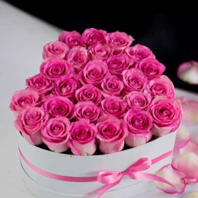 Round box of pink roses with a pink ribbon