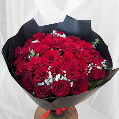 Bouquet of red roses with baby's breath in black wrapping
