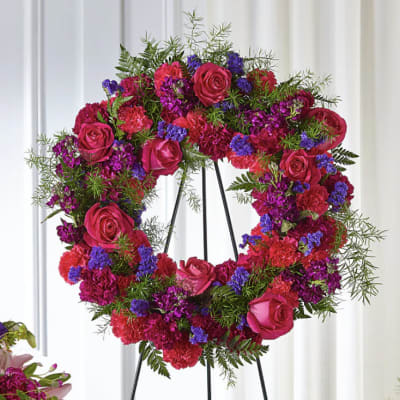 Heart-shaped floral wreath with pink roses and magenta carnations