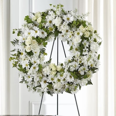 White floral wreath on a black easel